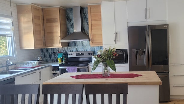 A modern kitchen with wooden cabinets, a stainless steel range, and a built-in oven.