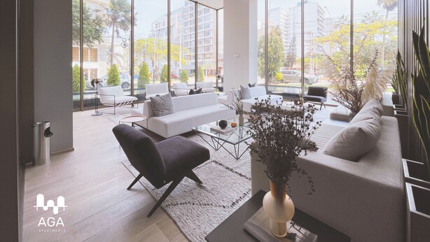 A modern living room with large windows, a sofa, a chair, and a coffee table. - Loft in Barranco | Sea View (Barranco)