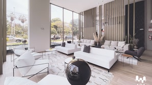 A spacious living area with large windows, a modern sofa set, and a decorative mirror. - Loft in Barranco | Sea View (Barranco)