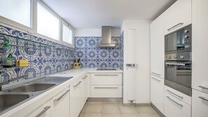A kitchen with white cabinets, a tiled backsplash, and a built-in oven. - Le Lido, Spectacular Beachfront Cap Ferrat  (Saint-Jean-Cap-Ferrat)