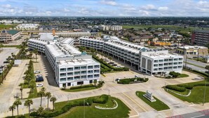 Un hôtel à plusieurs étages doté d’une cour intérieure, d’un parking et offrant une vue sur le paysage urbain environnant.