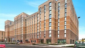 A multi-story building with a modern architectural design, featuring a grid-like facade and large windows. - Cozy 1 bed apartmrnt  Luton Airport (Luton)