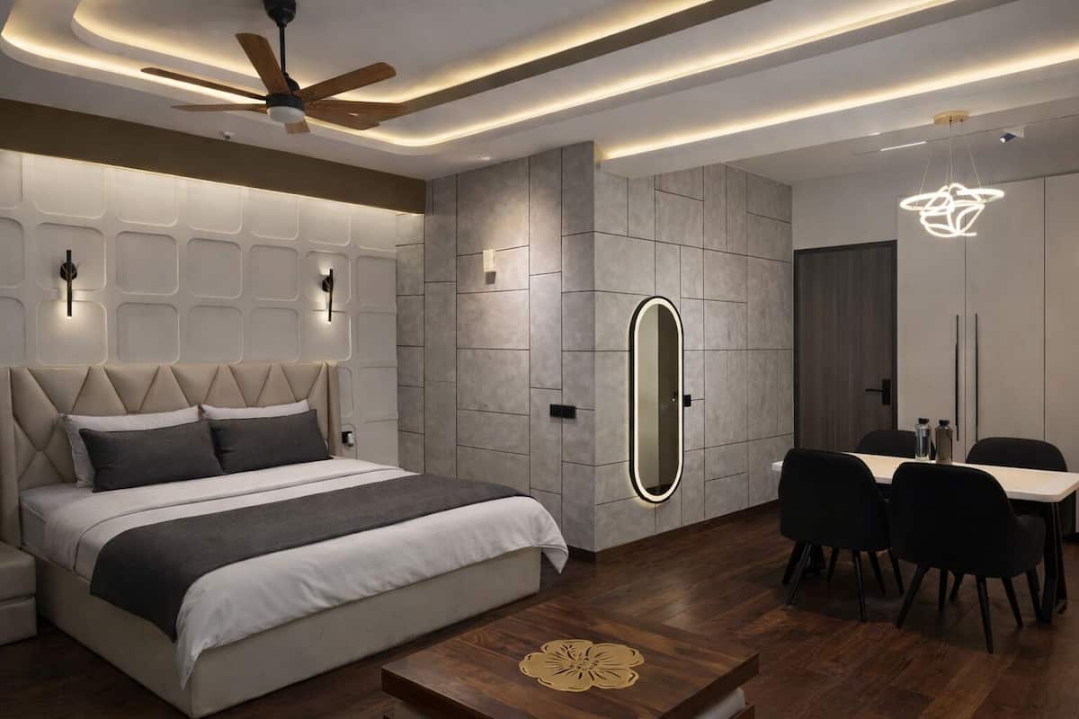 Un dormitorio moderno con cama, mesitas de noche, escritorio y sillas.