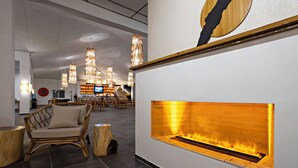A modern interior with a fireplace, wicker furniture, and a bar area. - Dive Spot Asia & Brumini Beach Resort (Boljoon)