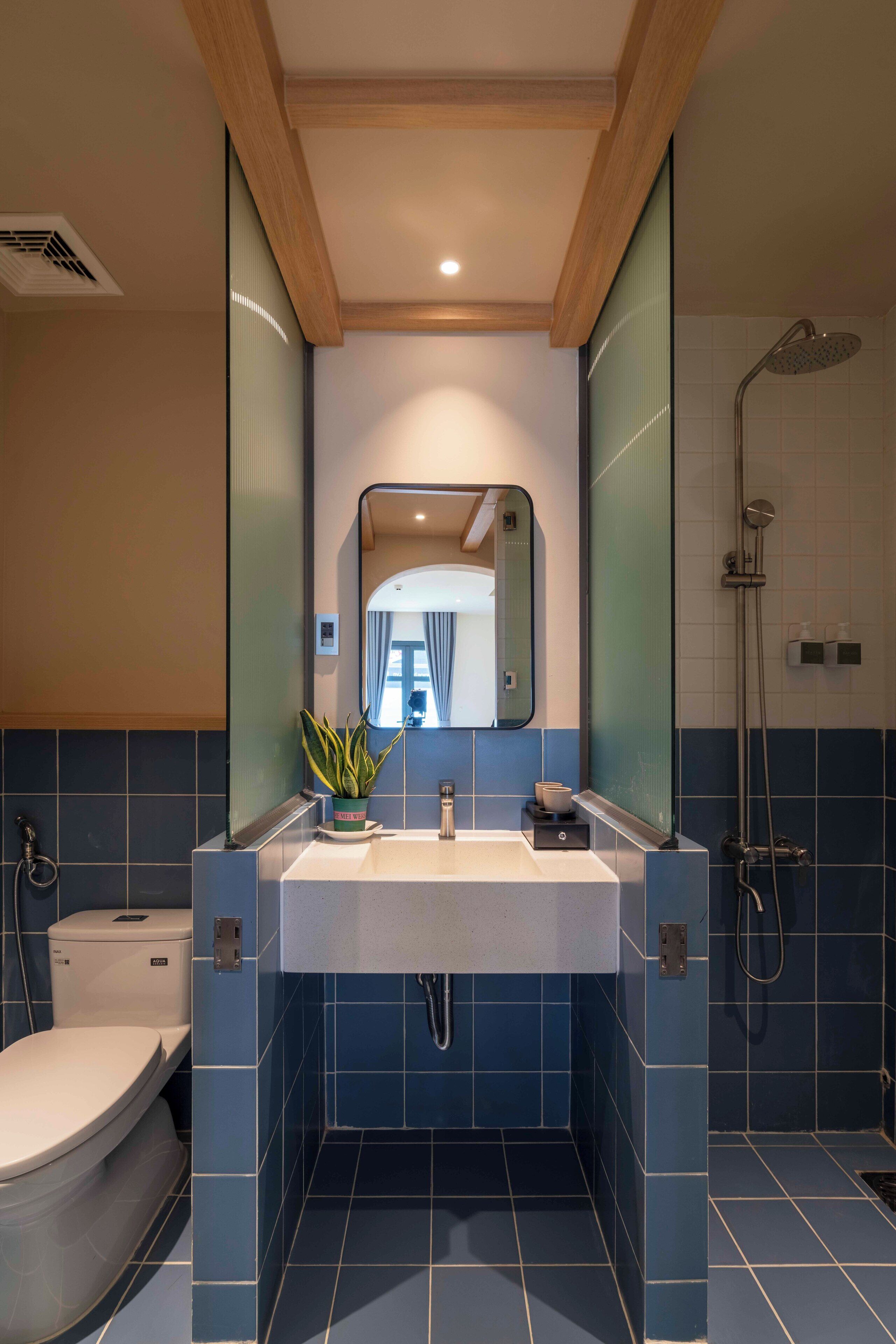 A modern bathroom with a dual sink vanity, a toilet, and a shower area.