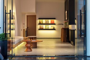 A modern hotel lobby with a reception desk, a seating area, and a wall displaying framed artwork. - DP Hotel (Tan Ninh)