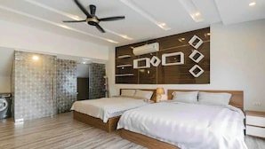A modern bedroom with two beds, a ceiling fan, and a wall-mounted air conditioner.