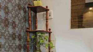 A corner shelf with a rolled towel and a potted plant.
