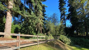 Una cerca de madera en un parque con árboles y césped.