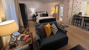 Una habitación de hotel con cama, sofá, escritorio y una silla.