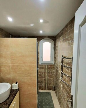 Ein Badezimmer mit Badewanne, Toilette und Dusche.
