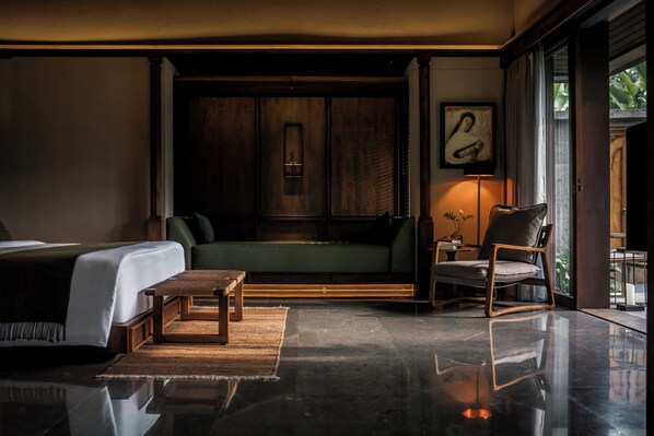 A modern bedroom with a bed, a sofa, a chair, and a wooden cabinet. - Janjisurga by Ekosistem (Cepaka)