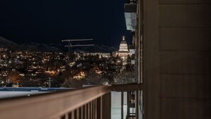 A nighttime cityscape with a prominent building with a dome, possibly a government or historical building, and a construction crane in the distance.