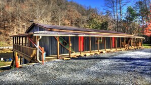 Eine Holzhütte mit Veranda, Treppe und einer kleinen Terrasse.