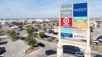 A large outdoor sign with multiple store names including Target, Dollar Tree, and Havilts Furniture.