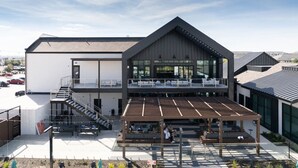 A modern building with a covered outdoor seating area and a staircase leading to an upper level. - Refined Living in a Vibrant Locale – Dream Stay (Pflugerville)