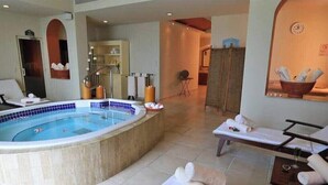 A spa area with a hot tub, lounge chairs, and towels.