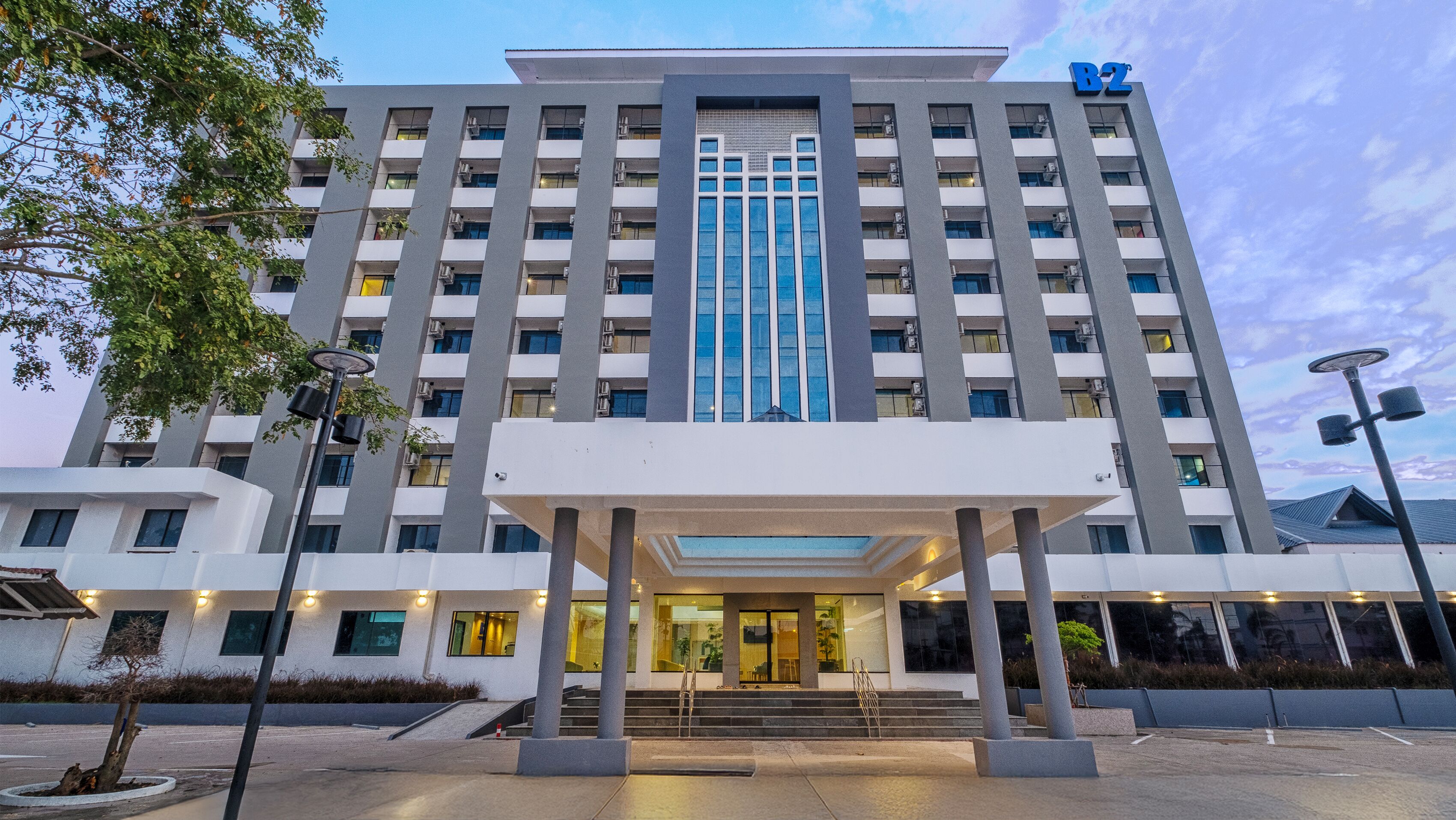 Un hotel moderno con entrada central, varios pisos y un llamativo letrero 'B2'.