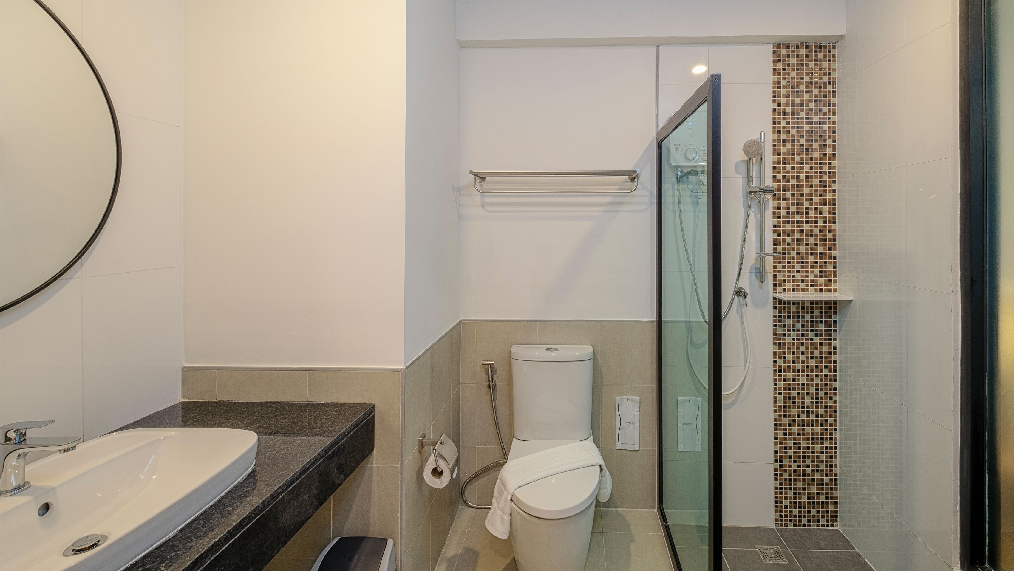 Ein modernes Badezimmer mit einer Duschkabine, einer weißen Toilette und einem Waschbecken mit Marmorplatte.