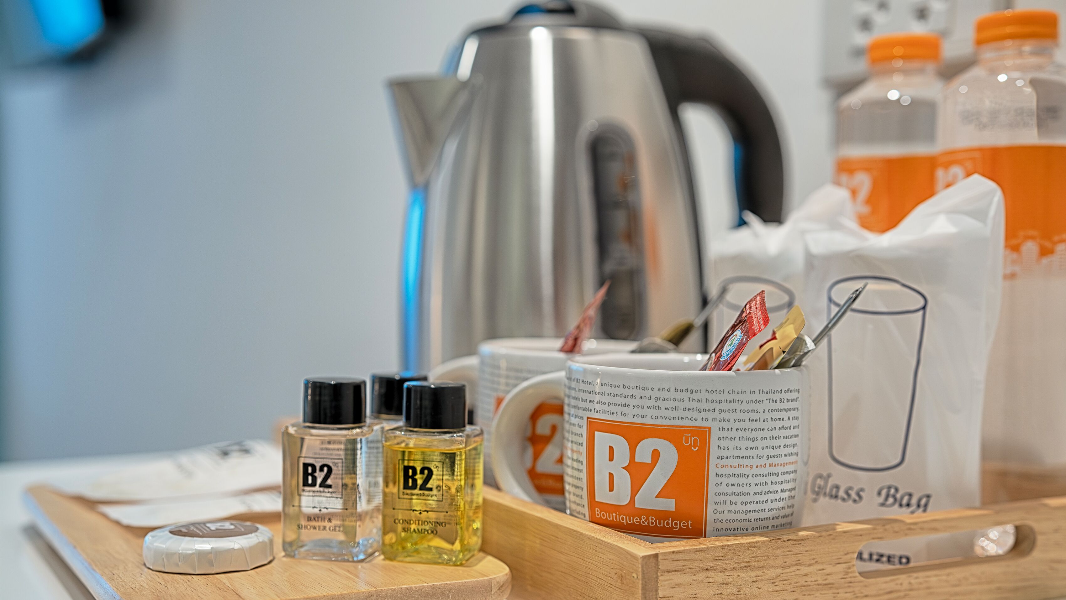 A tray with toiletries including B2 bath & shower gel, B2 conditioning shampoo, a glass bag, and a B2 boutique & budget sign.
