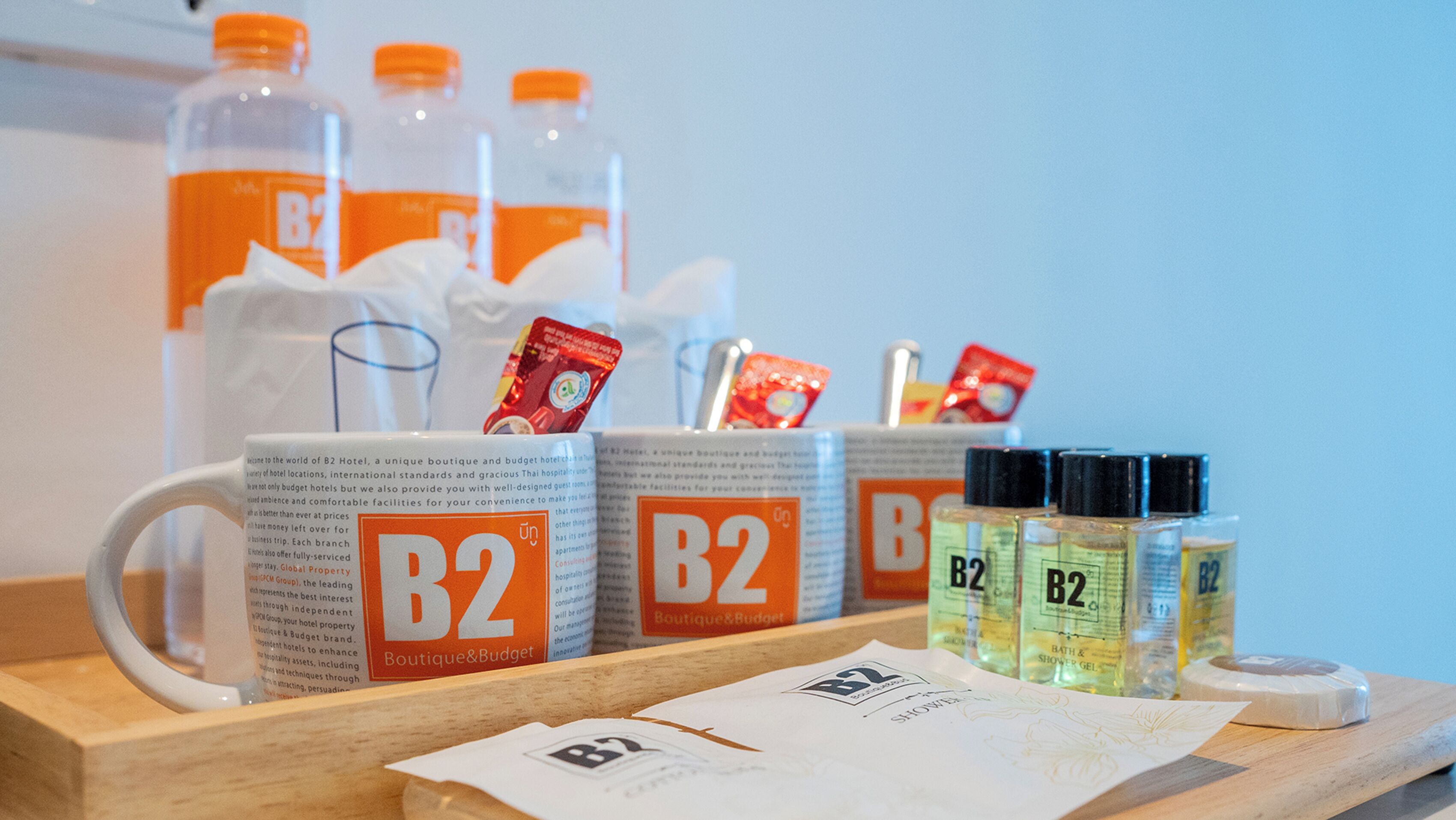 Presentatie van voorzieningen van B2 Boutique & Budget Hotel, zoals douchegel, een tissuedoos en een menukaart.