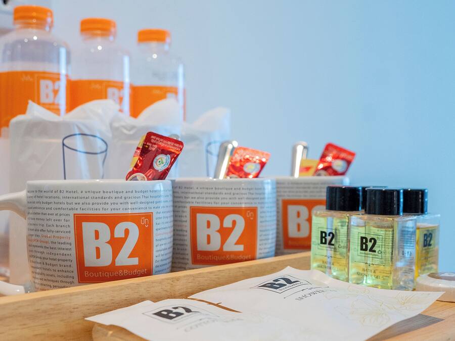 Presentatie van voorzieningen van B2 Boutique & Budget Hotel, zoals douchegel, een tissuedoos en een menukaart.