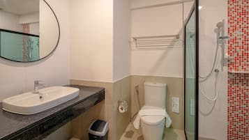 Un baño con lavabo, espejo, inodoro y ducha.