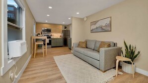 A modern apartment with a kitchen, dining area, and living room.