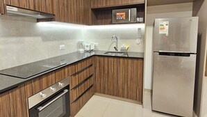 Una cocina moderna con armarios de madera, electrodomésticos de acero inoxidable y piso de baldosas.