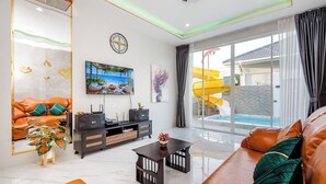 Una sala de estar moderna con un sofá, una mesa de centro, un televisor y un cuadro.