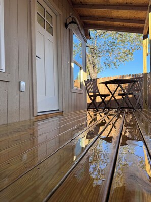 Eine Holzterrasse mit einer Bank und einer Tür.
