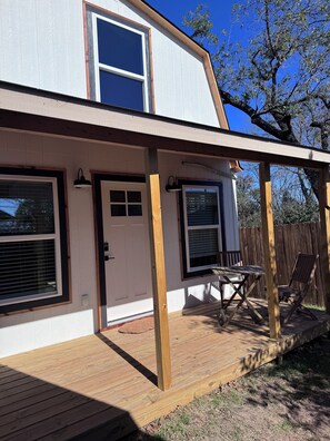 Ein zweistöckiges Haus mit überdachter Terrasse.