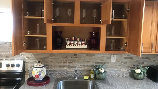 A kitchen with wooden cabinets, a granite countertop, a stainless steel sink, and a stove. - Charming 2-bedroom apartment in Pleasant Valley Stream with AC, WiFi (Valley Stream)