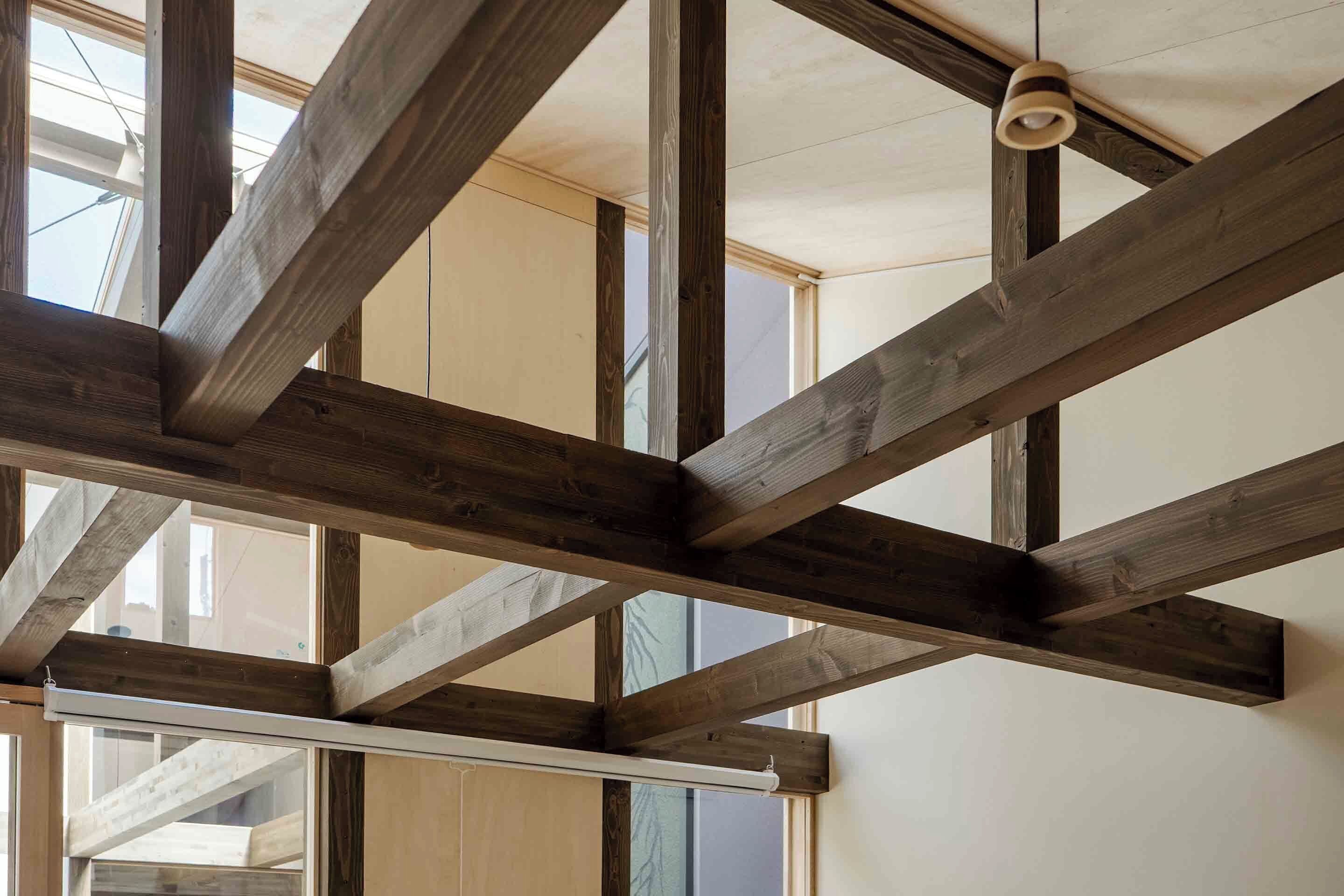 A room with exposed wooden beams and large windows.