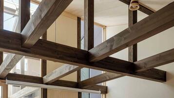 A room with exposed wooden beams and large windows.