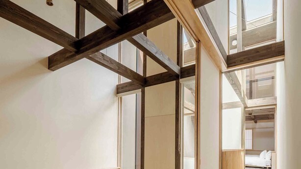 Une pièce de style japonais traditionnel, avec un sol recouvert de tatamis, une petite table en bois et un futon servant de lit.