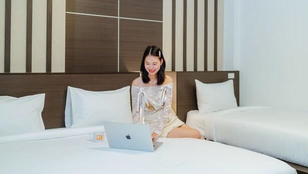A hotel room with a bed, a laptop, and a mug on the bed. - B2 Chiang Rai Resort Boutique & Budget Hotel (Chiang Rai)