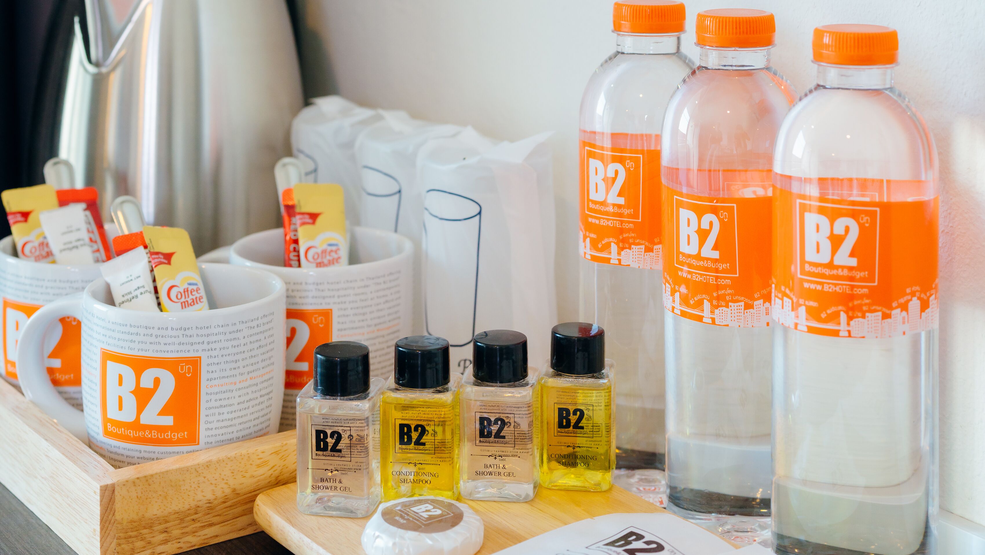 A display of B2 Boutique & Budget hotel toiletries including shower gel, shampoo, and conditioner.