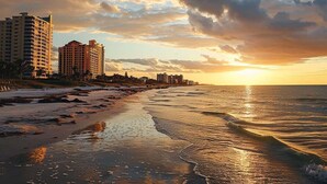 A beach with buildings in the background during sunset. - Luxury 5BR - Pool, Game Room, Mini Golf, Fire Pit (Marco Island)