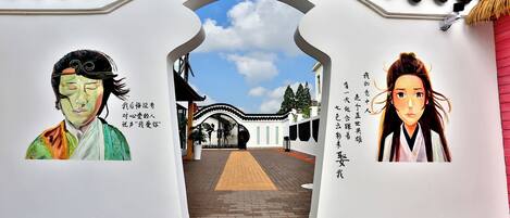A traditional gate with Chinese characters, leading to a courtyard with a tiled walkway.