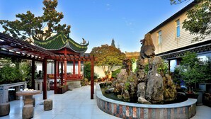 A traditional courtyard with a pavilion, a rock garden, and a tiled floor. - Shanghai Monegative Time Garden Hotel (Shanghai)