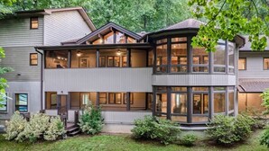 Ein modernes, zweistöckiges Haus mit großem Balkon und umlaufender Veranda.