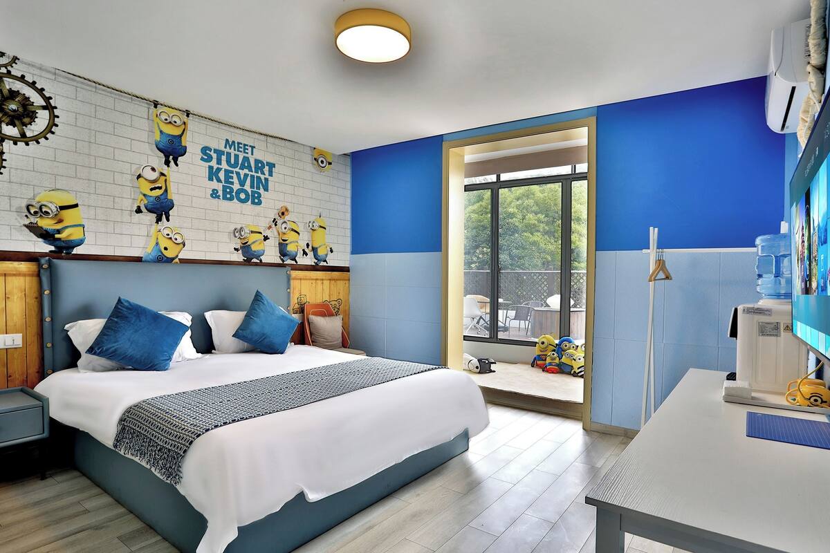 A hotel room with a bed, a desk, and a window.