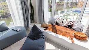 Una sala de estar moderna con un sofá, una alfombra de cuero y vistas a un patio exterior.
