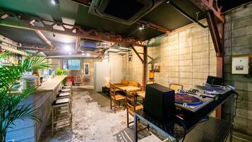 A bar area with a DJ setup, seating, and a bar counter.