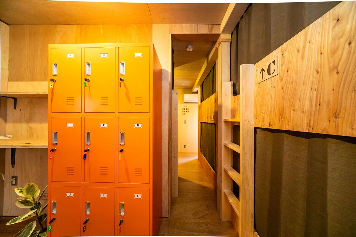 A hallway with orange lockers and wooden walls.