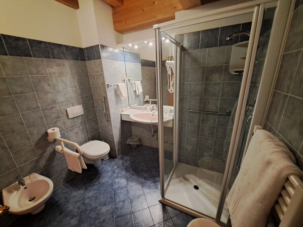 Ein Badezimmer mit Toilette, Bidet, Waschbecken und Duschkabine.