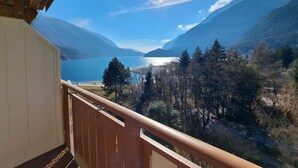 A balcony with a view of a lake, mountains, and a clear sky. - Lake & Nature Hotel Gloria (Molveno)