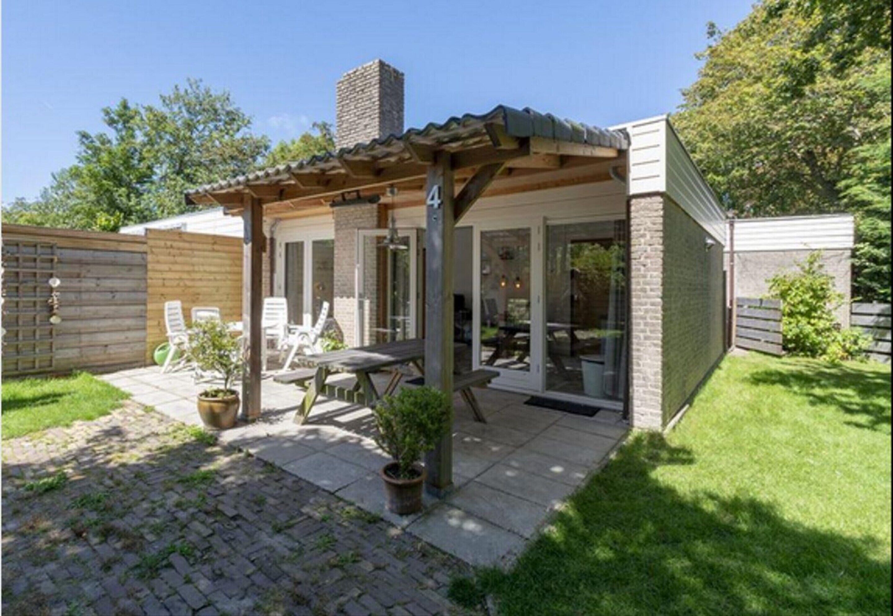 A small house with a patio, a chimney, and a number 4 on the wall.