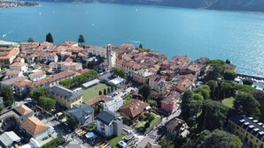 An aerial view of a lakeside town with historic buildings, a central square, and boats on the water. - Albergo Ristorante Grigna (Mandello del Lario)